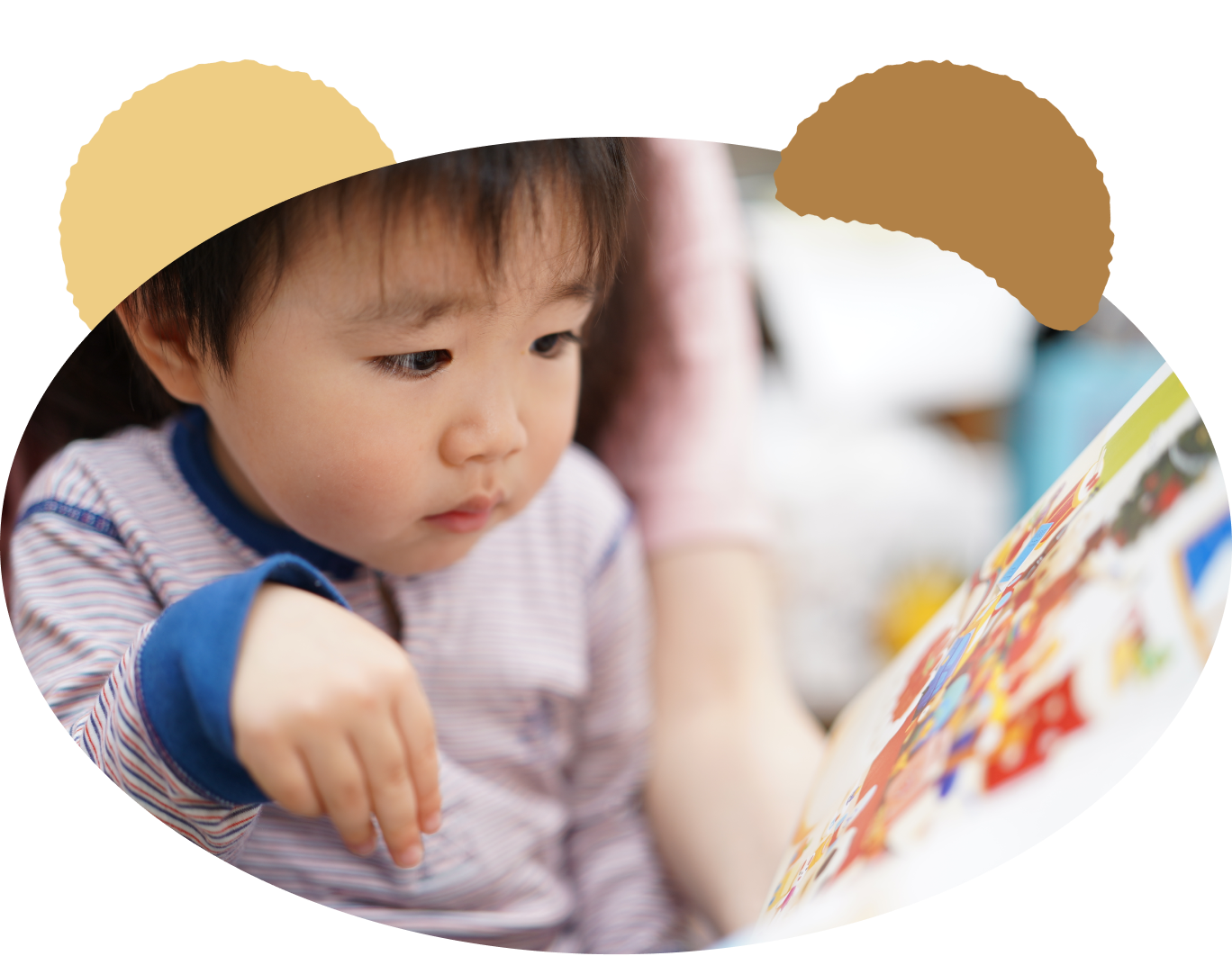絵本を読み聞かせて貰う幼稚園児